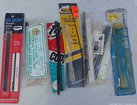 Front view of eight packaged scroll saw blade packs laid out