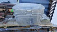 Galvanized rectangular washtub on bench