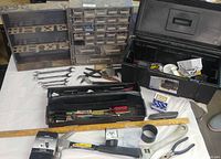 Overview of open toolbox, parts cabinet and assorted hand tools on table