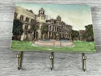 Front view showing 3D relief building scene and three hooks