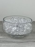 Side view of glass bowl filled with clear crystal-look pieces