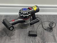 Left side view of Dyson V7 Trigger vacuum with mini motorized head, wall dock and charger