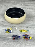 Overall shot showing cream Kokeshi bento bowl and five glass fish ornaments