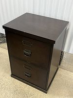 Front view of dark brown two-drawer wooden file cabinet