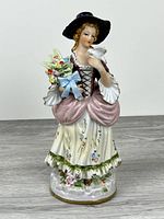 front view of porcelain woman with dove and flowers