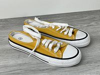 Side view of both sneakers showing uppers, laces, toe caps and midsoles