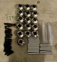 All components laid out: 16 lamp heads, tubes, stakes, diffusers, small parts