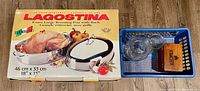 Box showing Lagostina roaster graphics alongside basket containing vases and recipe box