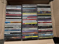 Open cardboard box showing two tall stacks of CDs