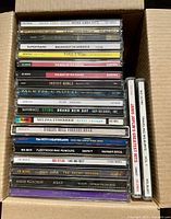 Open box showing spine titles of stacked CDs