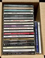 Full box showing top layer of CDs including Indigo Girls and Blue Rodeo spines