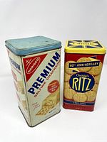 Both tins front view showing graphics and lids