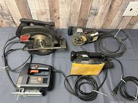 All four corded power tools with cords visible