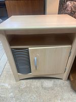 Front view of light maple laminate media cabinet showing top, open shelf, door and CD rack