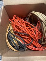 Tangled orange, beige and black cords inside box