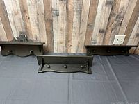 Front view of all three black distressed wall shelves with hooks