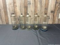 Five Barbicide jars standing in a row