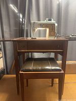 Machine mounted in wood cabinet with bench underneath