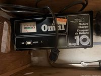 Front view of Omni 10-amp battery charger showing controls and ammeter