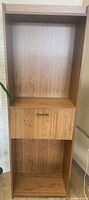 Front view of tall secretary cabinet showing open shelf, drop-front desk panel and lower shelf