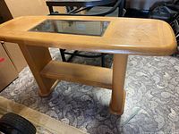 Full view of light oak console table with glass inset top and lower shelf