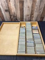 Wooden storage box open showing several rows of cards
