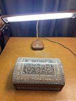Jewelry box and desk lamp together on table