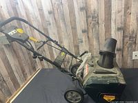 Side view of Yardworks snow blower showing housing, wheels, handle assembly