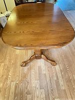 Top view of closed oak dining table on pedestal base