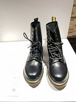 Front view of both boots upright showing laces, toe shape, yellow welt stitching