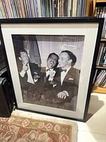 Full view of framed black and white print showing three men in tuxedos, black frame, off-white mat