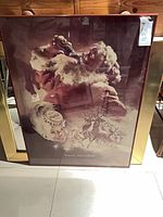 Full view of framed Coca-Cola Santa print leaning against wall