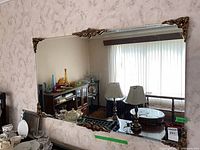 Front view showing entire mirror, ornate brass-tone decorations at corners and centre edges