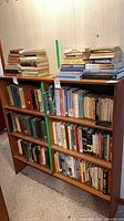 Front view of wood veneer bookcase with three shelves, books shown for scale