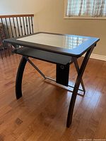 Full view of desk showing glass insert, curved legs and metal support