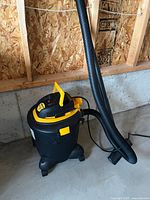 Full view of Shop-Vac with hose attached, on concrete floor
