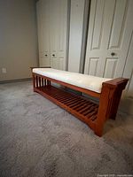 Full side view of bench showing cushion and slatted shelf