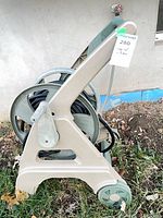 Side view of hose reel on ground showing frame, wheel and hose