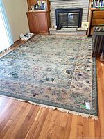 Full view of rectangular floral area rug on hardwood floor