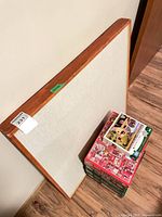 wood-framed fabric board leaning against wall beside puzzles