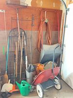 Overall view of garden tools, wheelbarrow, spreader, extension cord, planters
