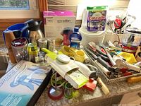 Countertop view of assorted utensils, appliances, detergent tub