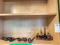 Shelf view showing all nine pipes and wooden stand