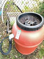 Rain barrel top view showing mesh lid, hose reel partially visible