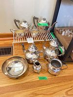 Both complete tea sets and footed bowl on floor and rack