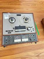 Front view showing control panel, hubs, VU meters, and take-up reel