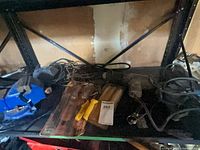 shelf with blue bench vise, heat gun, glue gun, packaged tools