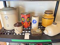 Entire lot on shelf including large crock, warming crock, two tins, mug, yellow crock, foot warmer