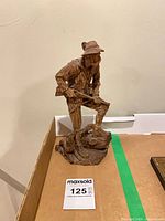 Full view of carved wood hunter figurine on box