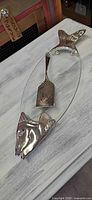 Top view of oval glass tray with fish head and tail mounts and matching metal server